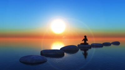 3D female in yoga pose on stepping stones in the ocean