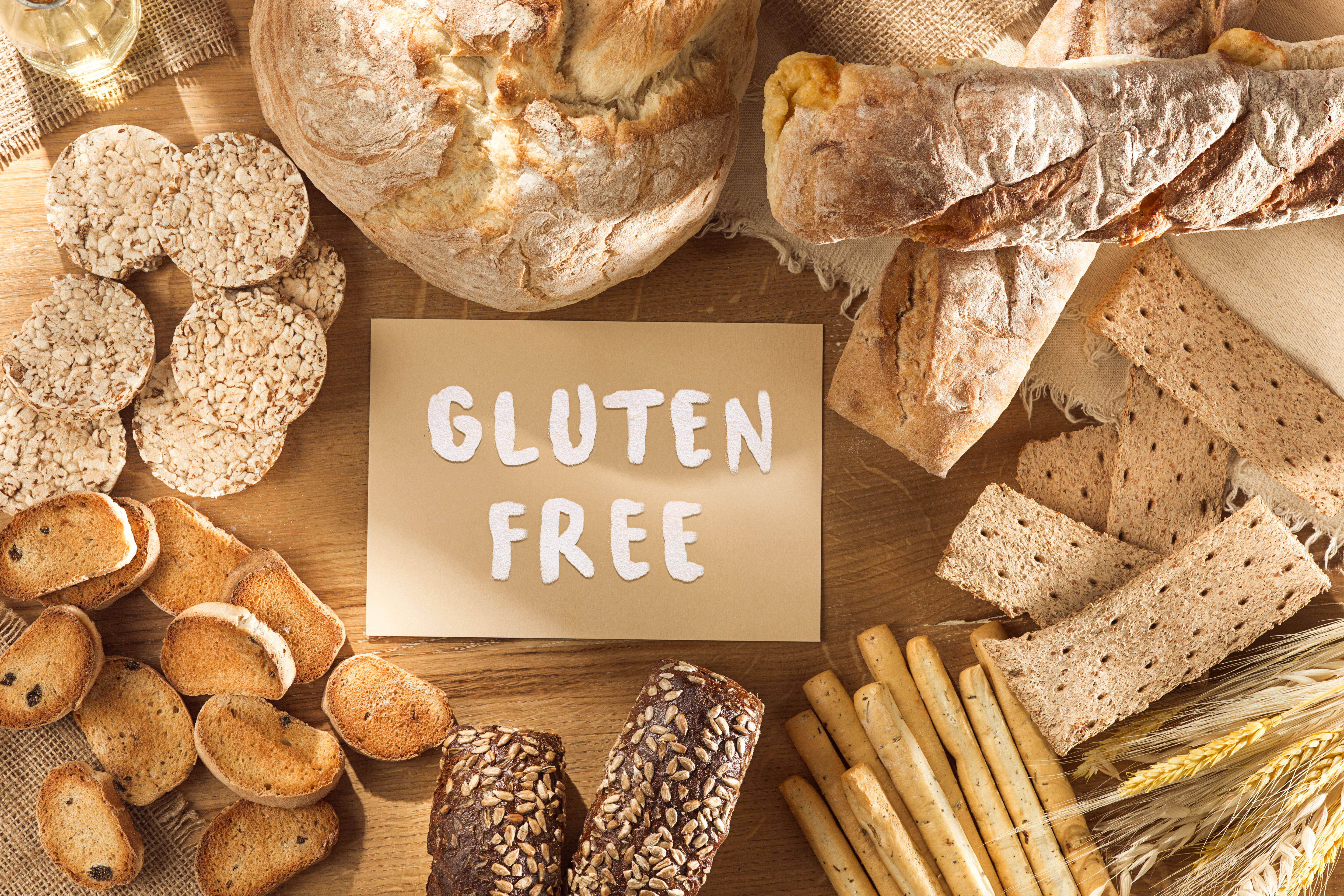 Gluten free food. Various pasta, bread and snacks on wooden background from top view